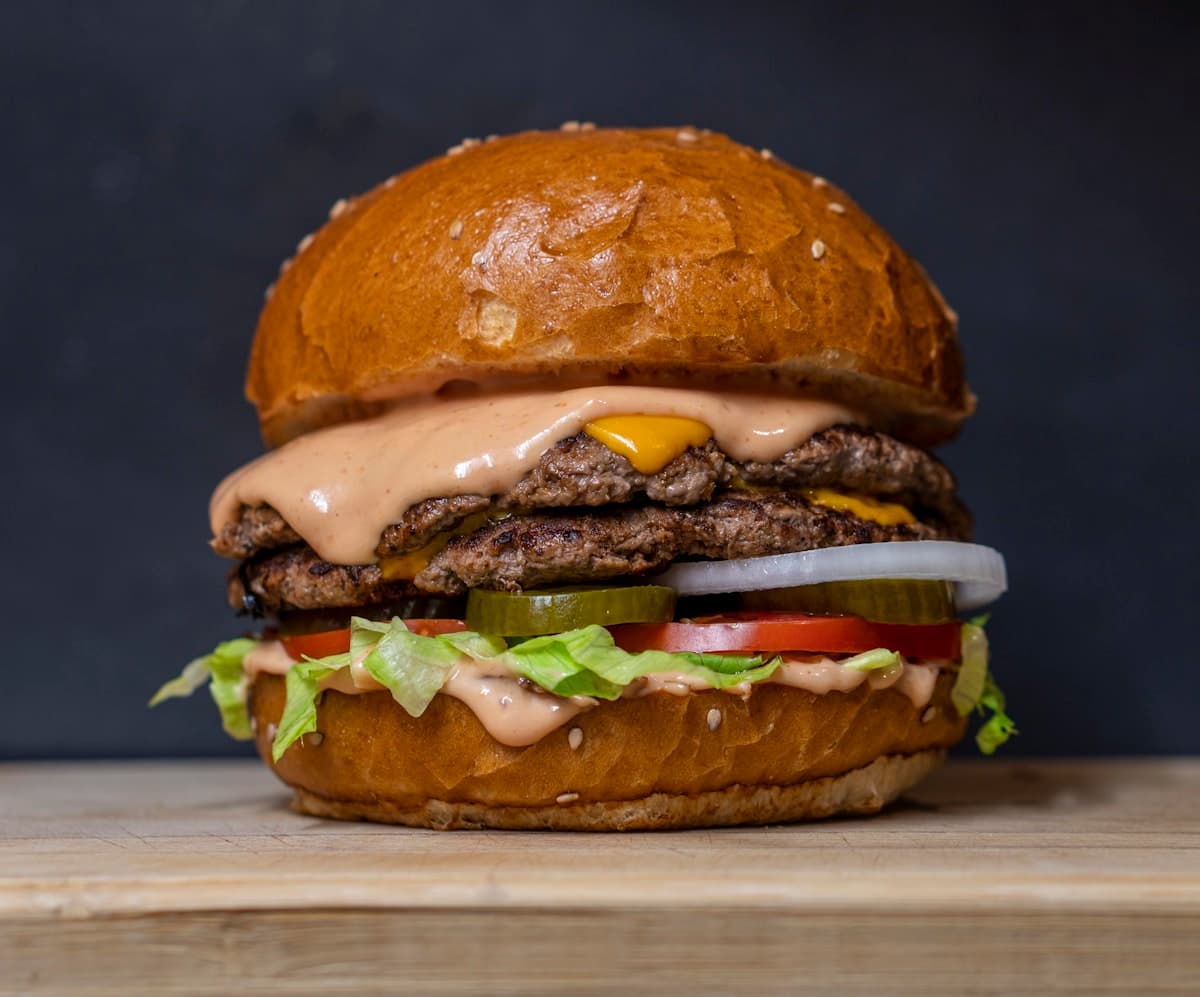 Hamburguesa artesanal con vegetales frescos servida sobre una tabla