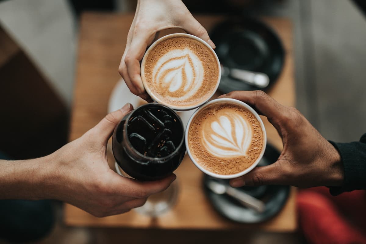 Taza de café de especialidad junto a granos tostados sobre una mesa