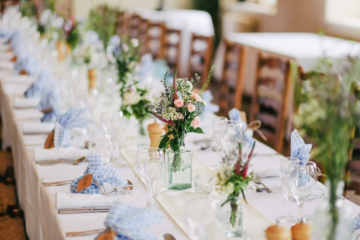 Mesa decorada con flores y luces para una celebración al aire libre