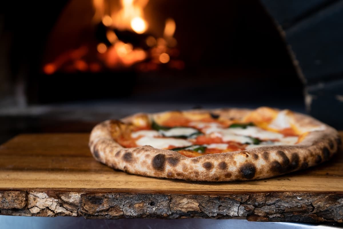 Pizza recién horneada con albahaca servida en un restaurante