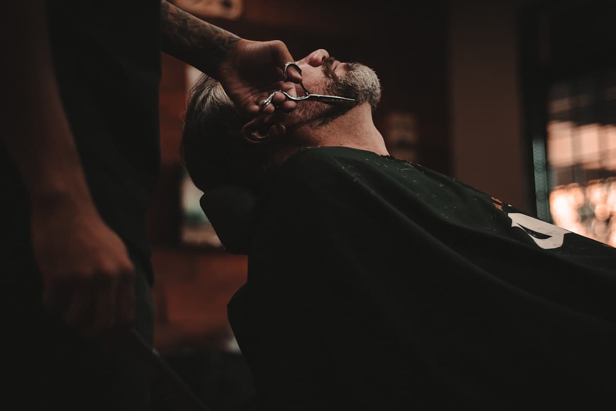 Barbero realizando un corte de cabello en una barbería moderna